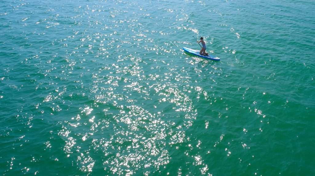 From Sea to Sky: Tulum’s Thrilling Adventure Activities 3 Paddleboarding on emerald ocean min