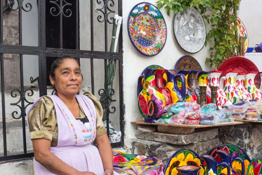Boho Chic to Artisan Unique: Tulum's Shopping Scene 3 Mexican colorful pottery vendor min